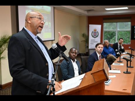 Balford Lewis (left), associate professor in the Faculty of Liberal Studies at the University of Technology, addresses public attitudes about crime and security in an AmericasBarometer forum at The University of the West Indies Regional Headquarters in St 