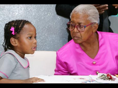 Unmoved by the occasion to honour principal of the Gospel Refuge Tabernacle Basic School, Althea Fuller (right), this youngster still sought answers from her, even as tributes were being paid to the educator.
