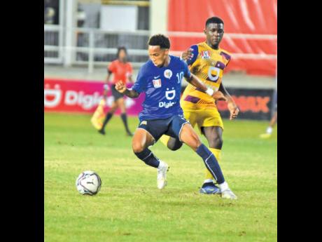 Jamaica College midfielder Kevaughn Wilson steps away from St Andrew Technical High’s Omar Reid during the ISSA/Digicel Manning Cup final at Sabina Park on December 2.