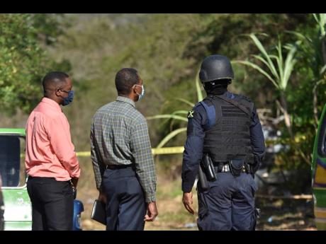 In this March 2022 photo police personnel are seen at the scene of a shootout in Zambia a community in Central Village, St Catherine where four people were killed in a police operation.