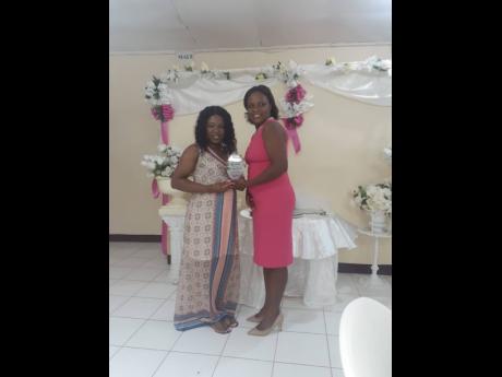 Suwayne Gordon (left) accepting her award from Marvett Watson for her 10 years of service at May’s Tiles and Bathroom Supplies 10th anniversary awards.