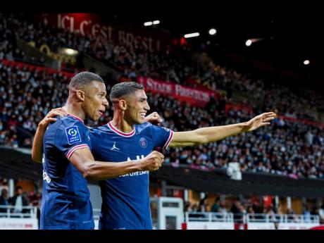 PSG’s Kylian Mbappe (left) celebrates with teammate Achraf Hakimi after scoring his side’s second goal during a French League One football match between Brest and PSG at the Francis-Le Ble stadium in Brest, France, on Friday, August 20, 2021.