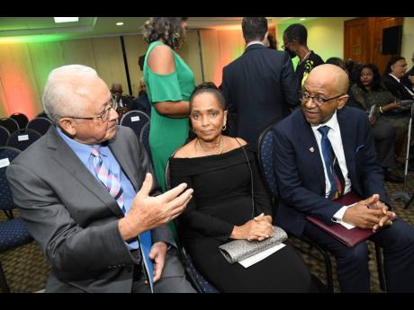Minister of Justice Delroy Chuck (left) speaks with John Bassie, global president of CIArb, and his wife Paulette at the investiture ceremony for CIArb global president 2023, where Bassie was elected president for 2023 at the UWI regional headquarters in K