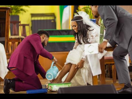 Theodore pours water on his wife Melissa’s feet during the foot-washing ceremony, done as a symbol of their commitment to serve each other in their marriage.