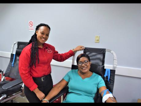 Debbie Ann Dobson (seated), deputy operations manager – human resources and training at the SAJ, is reassured by a Blood Bank staffer while making her donation.