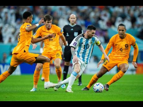Argentina’s Lionel Messi (second right) dribbles clear of  three Netherlands defenders during the World Cup quarterfinal match between the Netherlands and Argentina at the Lusail Stadium in Qatar last Friday.