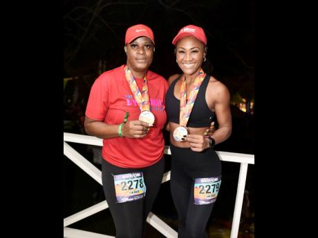 Dynamo member, Marcia Franklyn, shows off her medal alongside personal trainer, Patrice J. White.