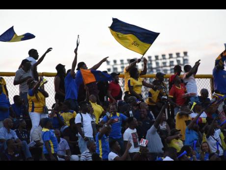 Clarendon College fans celebrate a goal during their team's Olivier Shield football contest against Jamaica College at the Stadium East Sports Complex on Wednesday.