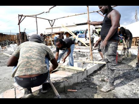 Vendors rebuild their stalls which were destroyed by an early morning fire on Sunday, December 11.