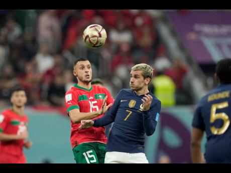 France’s Antoine Griezmann (right) heads a ball ahead of Morocco’s Selim Amallah during their World Cup semifinal football match at the Al Bayt Stadium in Al Khor, Qatar, yesterday.