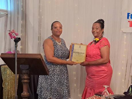 Retired teacher, Phyllis Cooke-Sterling (right), receives a presentation from Onex Bowen, immediate past president of the Jamaica Teachers’ Association’s St James Chapter and a past student of Somerton Primary School, during an appreciation dinner held