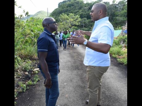 Agriculture and Fisheries Minister Pearnel Charles Jr (left) and Manchester North Western Member of Parliament Mikael Phillips in discussion during a tour of a rehabilitated farm road in Grass Piece, Maidstone, shortly after its opening on Thursday.