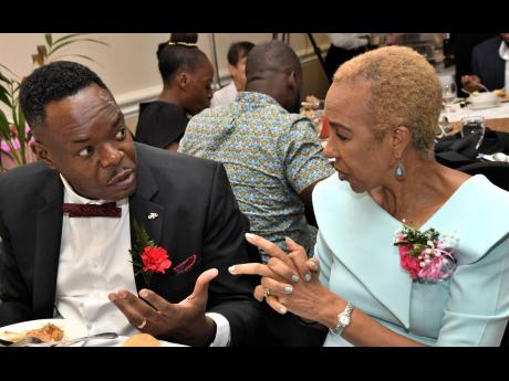 Dr Wayne Wesley, registrar and CEO of the Caribbean Examinations Council (CXC), chats with Education Minister Fayval Williams at a CXC staff appreciation luncheon at The Courtleigh Hotel and Suites in New Kingston on Friday.