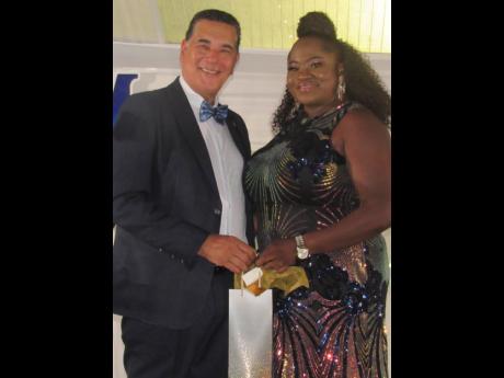 Shellian Robinson, deputy inspector of the poor at the St James Municipal Corporation,  presents a gift to Homer Davis, minister of state in the Office of the Prime Minister – West, at the local authority’s long service awards ceremony on Thursday.