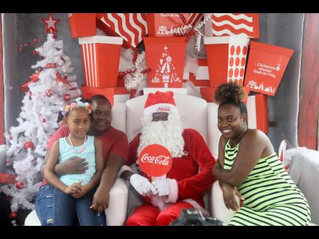 Lamoi Howard, eight-year-old Christina Temple and Ramona Howard pose for a photo with Santa (Wally Walters).