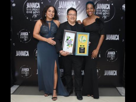 The sole Jamaican to win an award as a top producer, Dave Chin Tung of Go Jamaica Travel, poses with his two plaques while flanked by the Jamaica Tourist Board’s Victoria Harper (left) and the Ministry of Tourism’s Fiona Fennell at the Jamaica Travel S