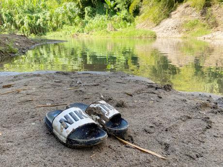 The slippers of the late Remo Douglas, a 34-year-old resident of United Kingdom, who died after drowning in Thomas River, Clarendon, on Friday. 