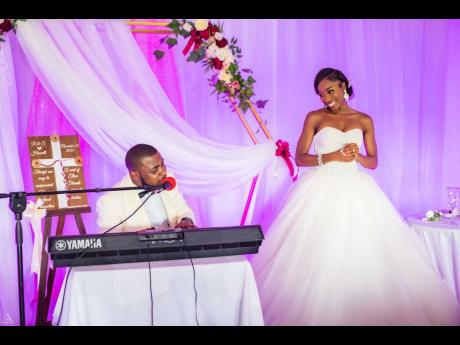 The bride blushes as her groom, Sheldon, serenades her in song.
