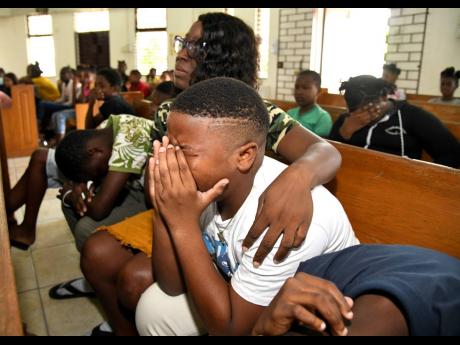 Jodi-Ann Charron, a grade five teacher, consoles students of Dupont Primary School whose classmate, Brehanna Sindale, drowned three days earlier in Chapelton, Clarendon.