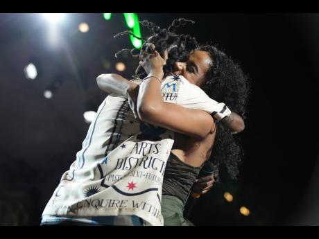 Watch love! Popcaan (left) hugs Toni-Ann Singh during the performance of their song ‘Next To Me’ at the Burna Boy concert. 