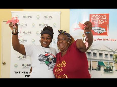 Sisters Jacinth (left) and Carla Johnson show off the keys to their new homes in Seville Heights, St Ann, that were officially handed over to them by Prime Minister Andrew Holness on Monday, under the New Social Housing Programme.