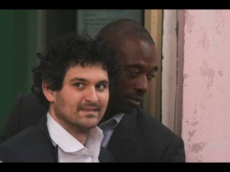 
FTX founder Sam Bankman-Fried (left) is escorted from the magistrate court in Nassau, Bahamas, on Wednesday, December 21, after agreeing to be extradited to the United States.