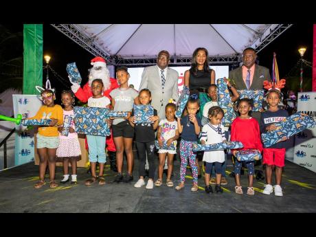 Councillor Leeroy Williams, Mayor of Montego Bay (right-back), joins Verona Carter, vice-president, New Fortress Energy (centre) and Bishop Conrad Pitkin, Custos of St James, in handing out toys to the hundreds of children who gathered for the city’s ann