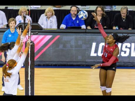 Louisville’s Aiko Jones (15) spikes the ball against Texas’ Logan Eggleston (second left)and Asjia O’Neal in the first set during the NCAA college volleyball championship finals, Saturday, December 17, 2022, in Omaha, Nebraska. 