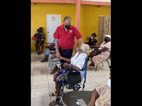 Don Wehby, chairman of the Grace and Staff Foundation and GraceKennedy’s Group CEO, shares a moment with a senior citizen from Dela Vega City in Spanish Town during the foundation’s Christmas outreach.