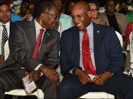 United States Ambassador to Jamaica Nick Perry (left) greets Minister of Industry, Investment and Commerce, Senator Aubyn Hill, during the city's Christmas tree-lighting ceremony.