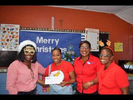 Principal of the Marcus Garvey Basic School, Judonna Smikle (second from left), is all smiles as she receives a token from the SAJ team of Dionne Mason-Gordon, operations manager – member services; Debbie Ann Dobson, deputy operations manager – HR and 
