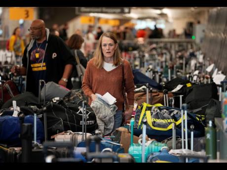 Travellers wade through the field of unclaimed bags at the Southwest Airlines luggage carousels at Denver International Airport in the United States on Tuesday. Thousands of cancelled flights across the United States and Canada have resulted in many passen