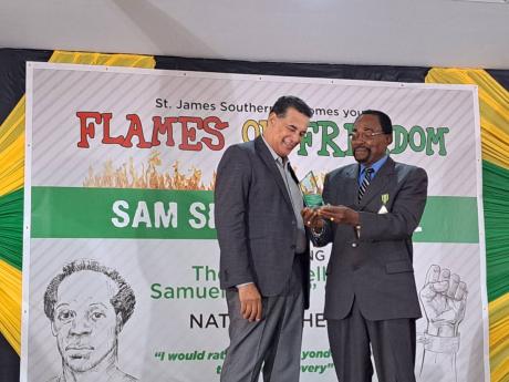 Homer Davis (left), state minister in the Office of the Prime Minister West and the member of parliament for St James Southern, makes a presentation to Shalman Scott, historian on National Hero Samuel Sharpe and former mayor of Montego Bay, following the l