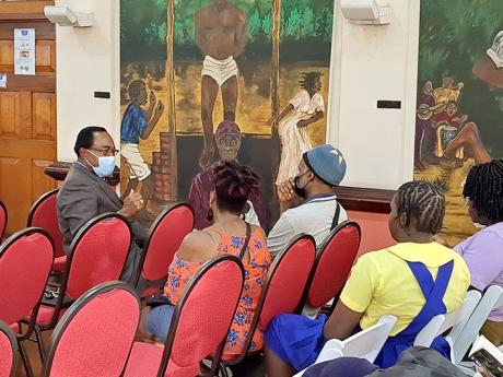 Shalman Scott (left), a historian on National Hero Samuel Sharpe and a former mayor of Montego Bay, talks with residents attending the Sam Sharpe Flames of Freedom Lecture at the Montego Bay Cultural Centre in  St James on Thursday, December 22.