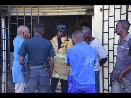 Workers at LynMax Bakery along Slipe Road in Kingston explain the genesis of the fire to a firefighter shortly after the blaze was extinguished on Wednesday morning.
