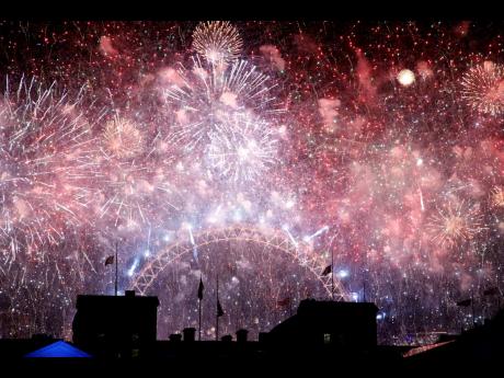 Fireworks illuminate the sky above the London Eye as viewed from Horse Guards Parade in central London to celebrate the New Year.