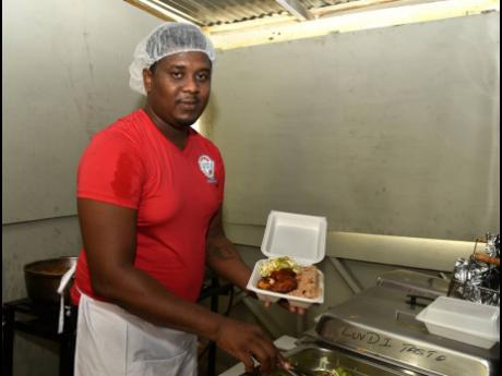 Chef Jovaine Lawrence presents one of the restaurant’s popular dishes: barbi-fried chicken, served with rice and peas and fresh vegetables. 
