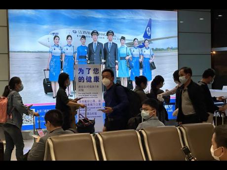 AP Photos 
Passengers prepare to board a flight at the airport in north-central China’s Jiangxi province on November 1, 2022. The Chinese government said on December 27, 2022 that it will start issuing new passports as it dismantles antivirus travel barr