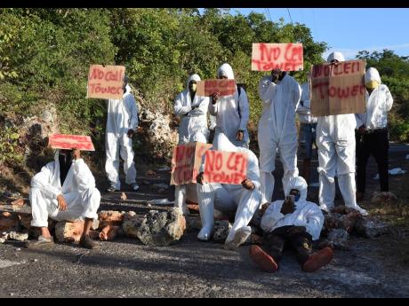 Residents of Portsea in Junction, St Elizabeth, protest against the erection of a cell Tower in their community on Thursday morning. The residents were out from as early as 4:30 a.m., using rocks and trees to block the Cheapside to Malvern main road.