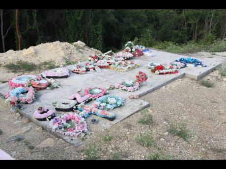 The multi-sectional grave where Kemesha Wright and her four children were laid to rest at Sutton Memorial Cemetery in Clarendon is laden with wreaths, teddy bears and dolls. Unfinished, the five graves bore no headstones, evidence of a loss too great for o
