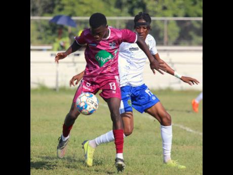 Chapelton Maroons’ attacker Kaheim Dixon (left) is hounded by Vere United’s central midfielder Javier Brown during their Jamaica Premier League (JPL) encounter at the Wembley Centre of Excellence today. The match ended in a 0-0 draw.