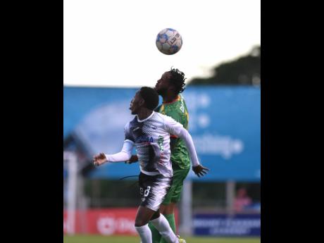 Cavalier's Dwayne Allen (left) battles Roashane Sharpe of Humble Lion in the air, during their Jamaica Premier League match at the Anthony Spaulding Sports Complex tonight. Cavalier defeated Humble Lion 2-1 in the match, which preceded that between Arnett 