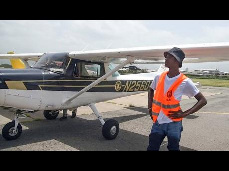 Rolando Grant stands beside a small plane in which he had his first flight lesson during a pilot training course at the Aeronautical School of the West Indies in July 2022. 