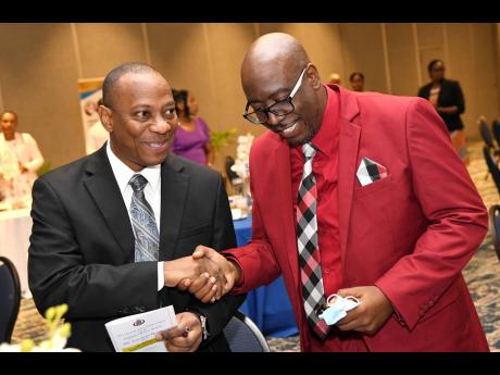 Pastor Dr Gary Buddoo-Fletcher (left), chaplain of the JCF, speaks with Rev Dr Courtney Faulknor, assistant chaplain, at the Non-Geographic Formations No. 2 Chaplaincy Services Branch, Jamaica Constabulary Force New Year’s Prayer Breakfast at The Jamaica