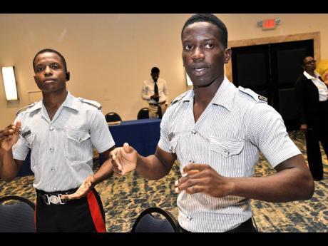 Constables Christopher Strachan, (left) and Jason Smart in worship at the Non-Geographic Formations No. 2 Chaplaincy Services Branch, Jamaica Constabulary Force New Year’s Prayer Breakfast.