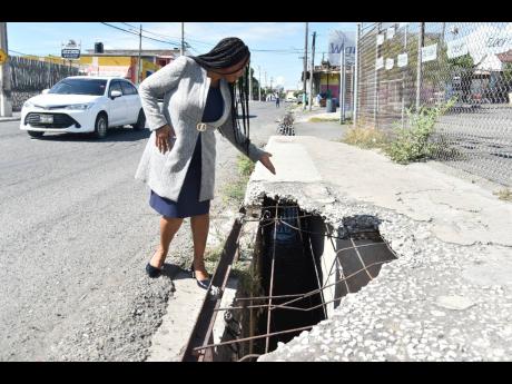 Jacqueline Lewis, councillor for the Norman Garden Division, points to one of several open storm drains in the area which she says she been appealing to the Kingston and St Andrew Municipal Corporation and the National Works Agency to address for some four