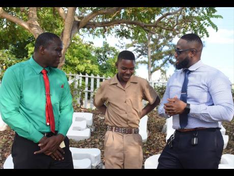 Rushawn Ewears (centre) in conversation with his teachers Kamar Findlay (left), who is also his rugby coach,  and Raoul Chambers, a guidance counsellor, at the B.B. Coke High School.