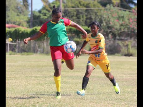 Real Mobay AFC player Zenesha Williams (left) gets ready to make a clearance ahead of a challenge by Vere United’s Jully-Ann Howard during their Jamaica Women’s Premier League (JWPL) encounter at the Wembley Centre of Excellence on Sunday, December 4. 