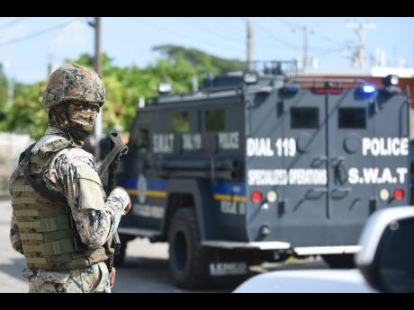 In this 2021 photo Special Weapons and Tactics unit and JDF soldiers are seen at a section of Cumberland in Portmore, St Catherine. 