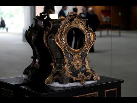 A damaged 17th-century clock, gifted to Portuguese royalty by Louis XIV, stands on display in the entrance hall of the presidential office at Planalto Palace after the storming of public buildings by supporters of former President Jair Bolsonaro in Brasili